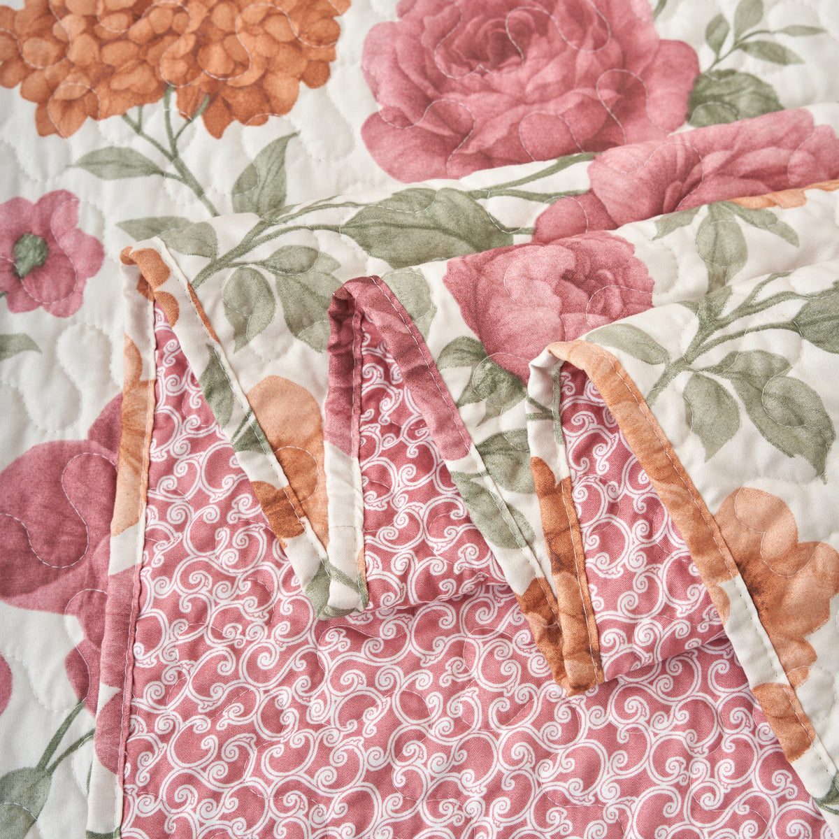 Edge binding detail of the reversible terracotta floral quilt bedspread with clean stitched borders