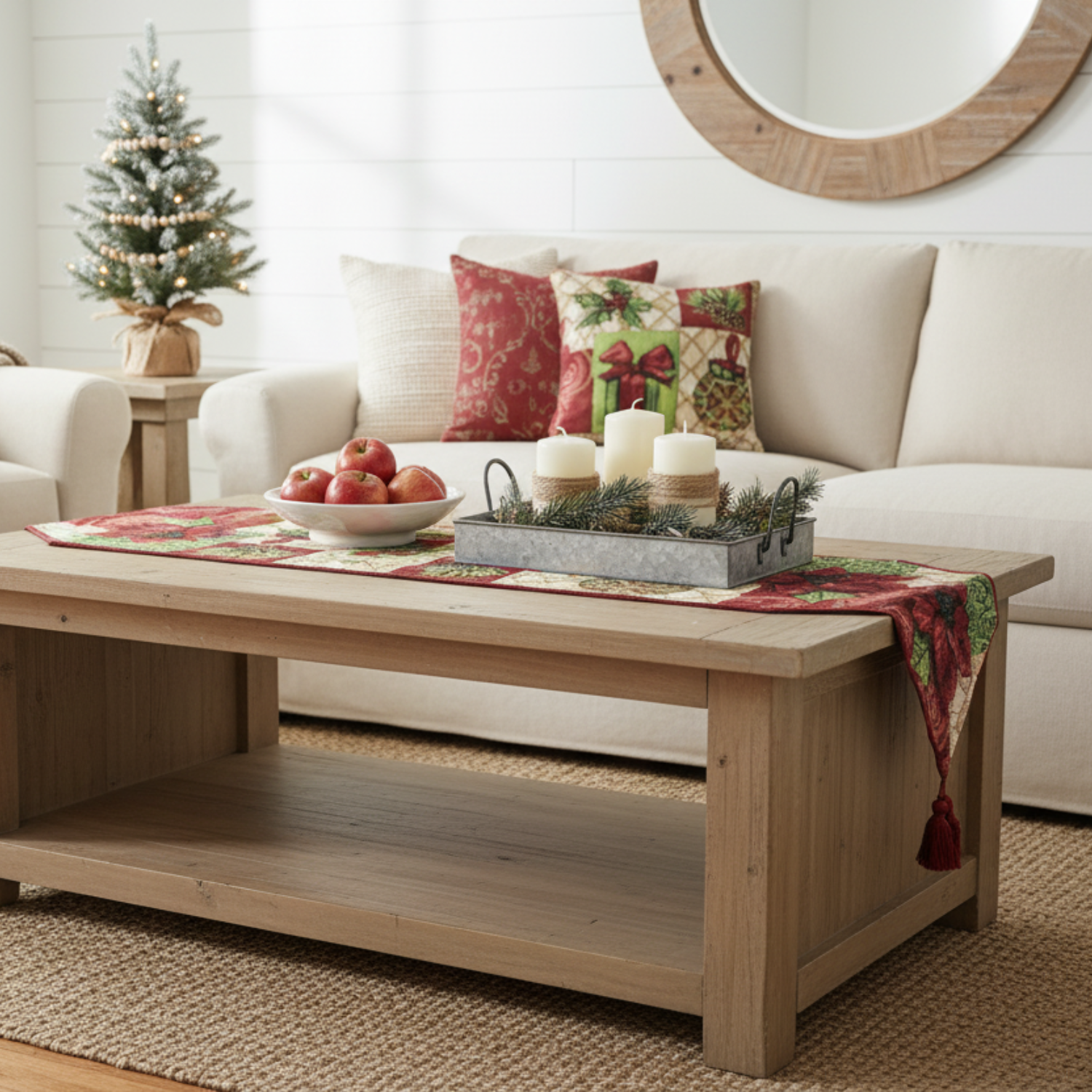 Living room with a coffee table decorated for Christmas, featuring apples, candles, and a small tree.