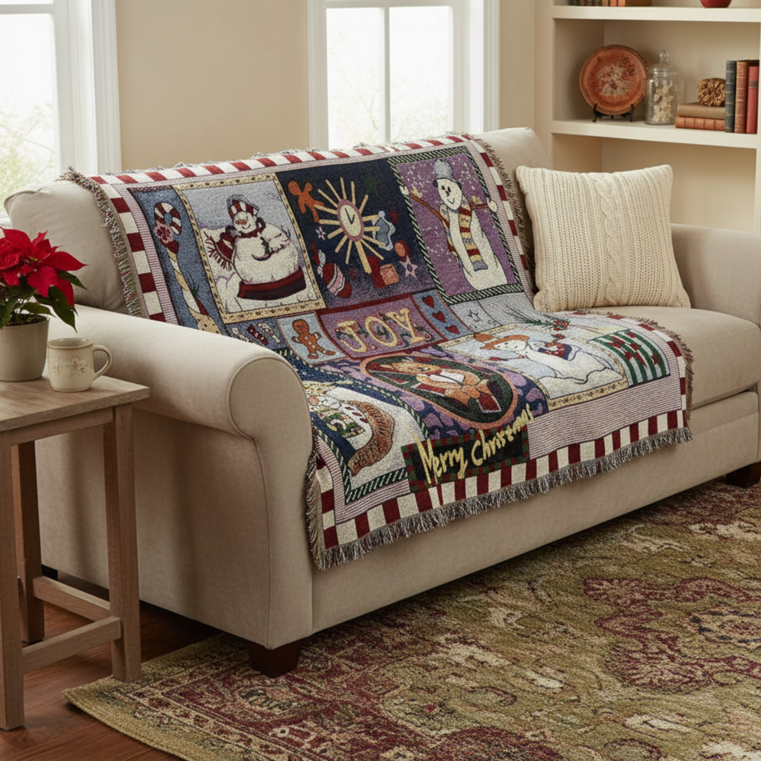 Decorative Christmas-themed blanket on a beige sofa in a living room setting.
