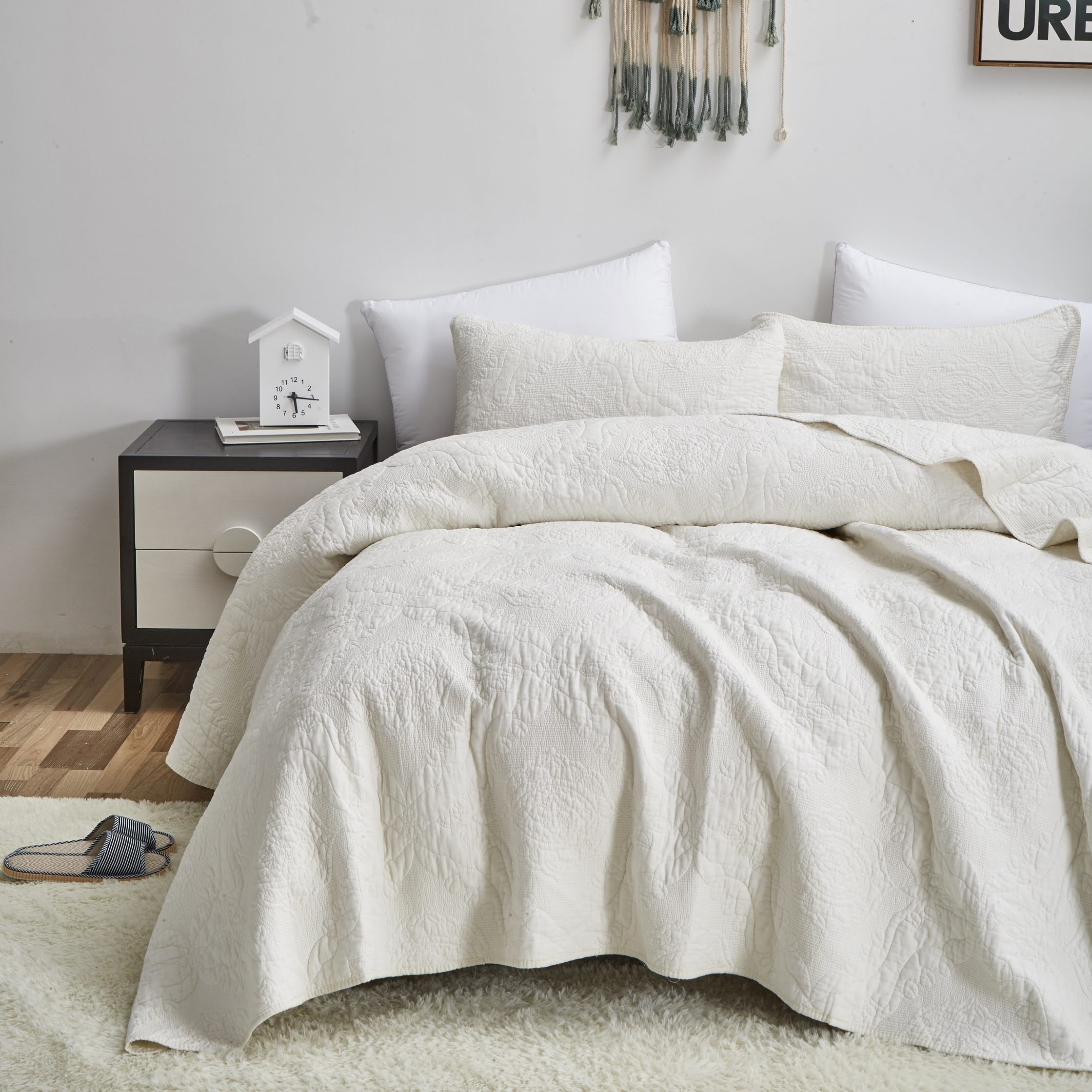 ivory white quilt and pillow shams on relaxed cozy bed. click to view all quilts and bedspreads. elegant fancy chic solid matelassé quilt bedspread blanket bedding comforter bed spread cover