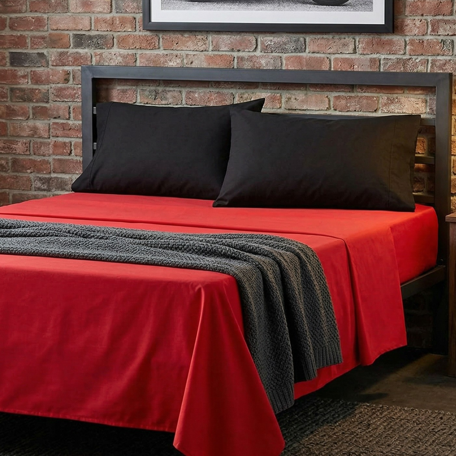 Tache vibrant red and black 100% cotton 4-piece sheet set on a bed.