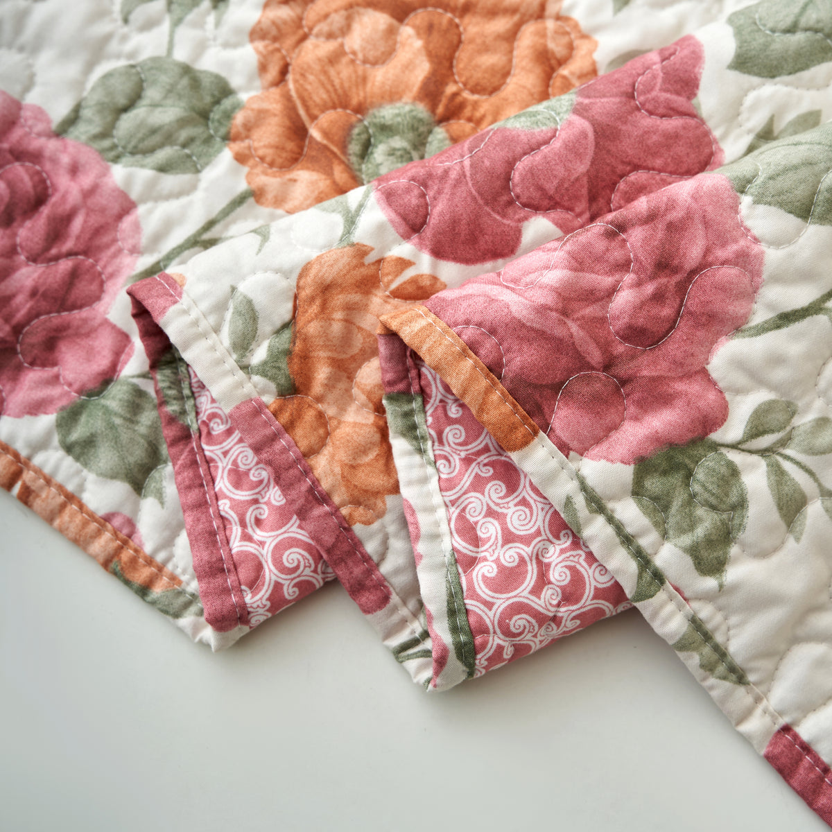 Reverse side of the terracotta rose floral quilted table runner showing the ivory scroll print