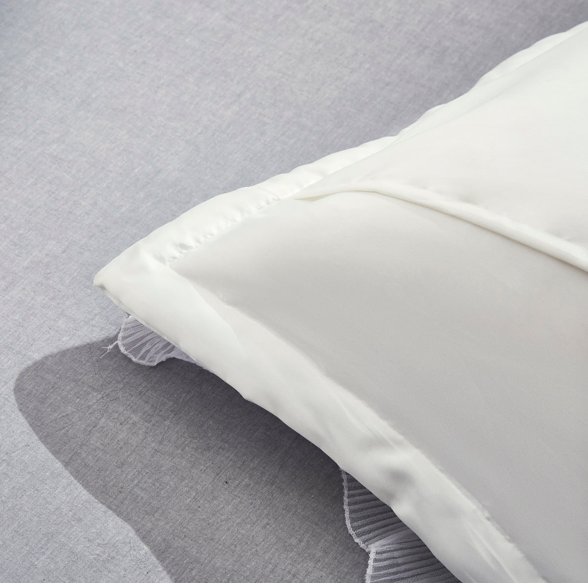 White satin luxury Euro sham with ruffle trim styled on a bed, Tache Delicate Rose MA125