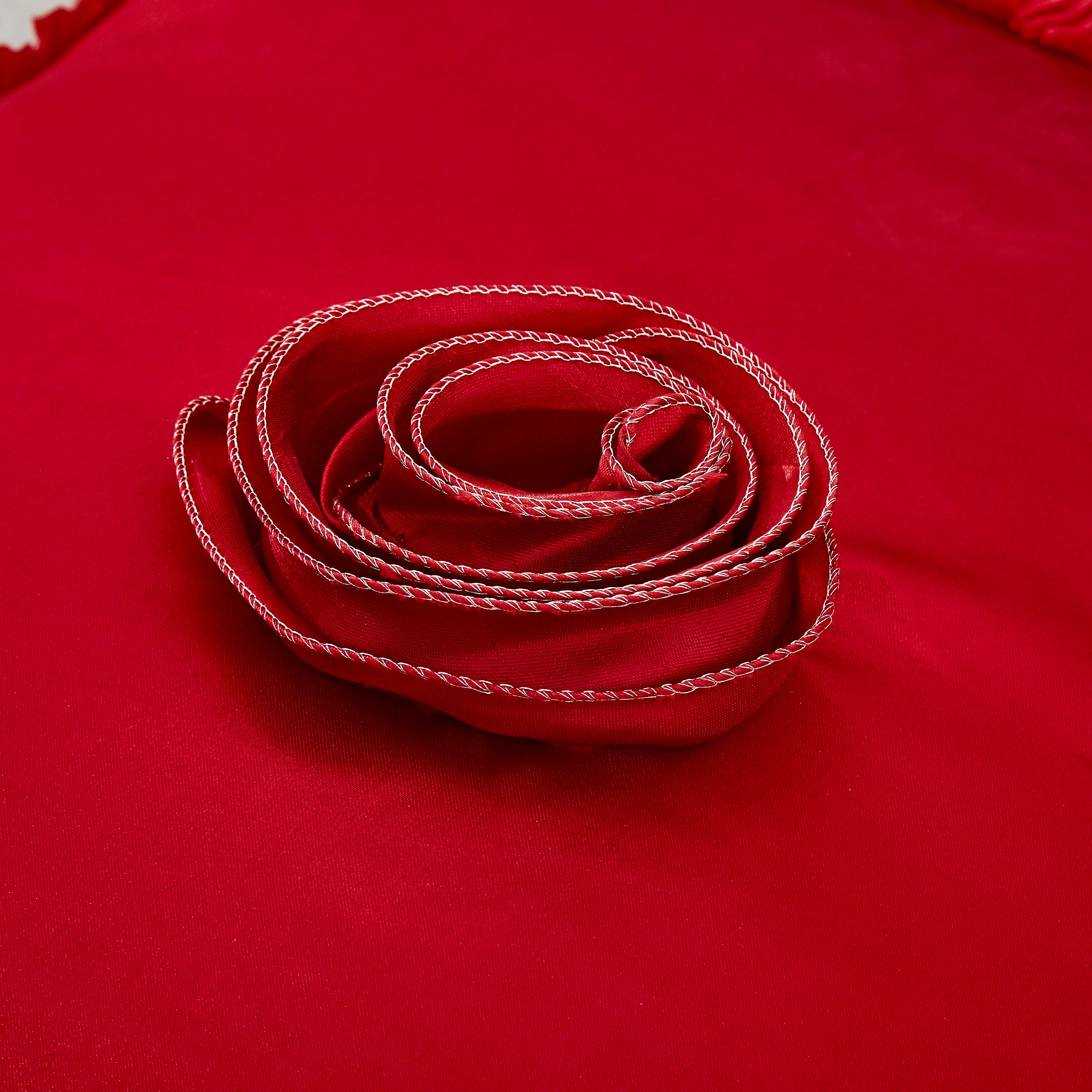 Close-up detail of rose embellishment and satin ruffle trim on the Tache Romantic Red Rose Euro sham