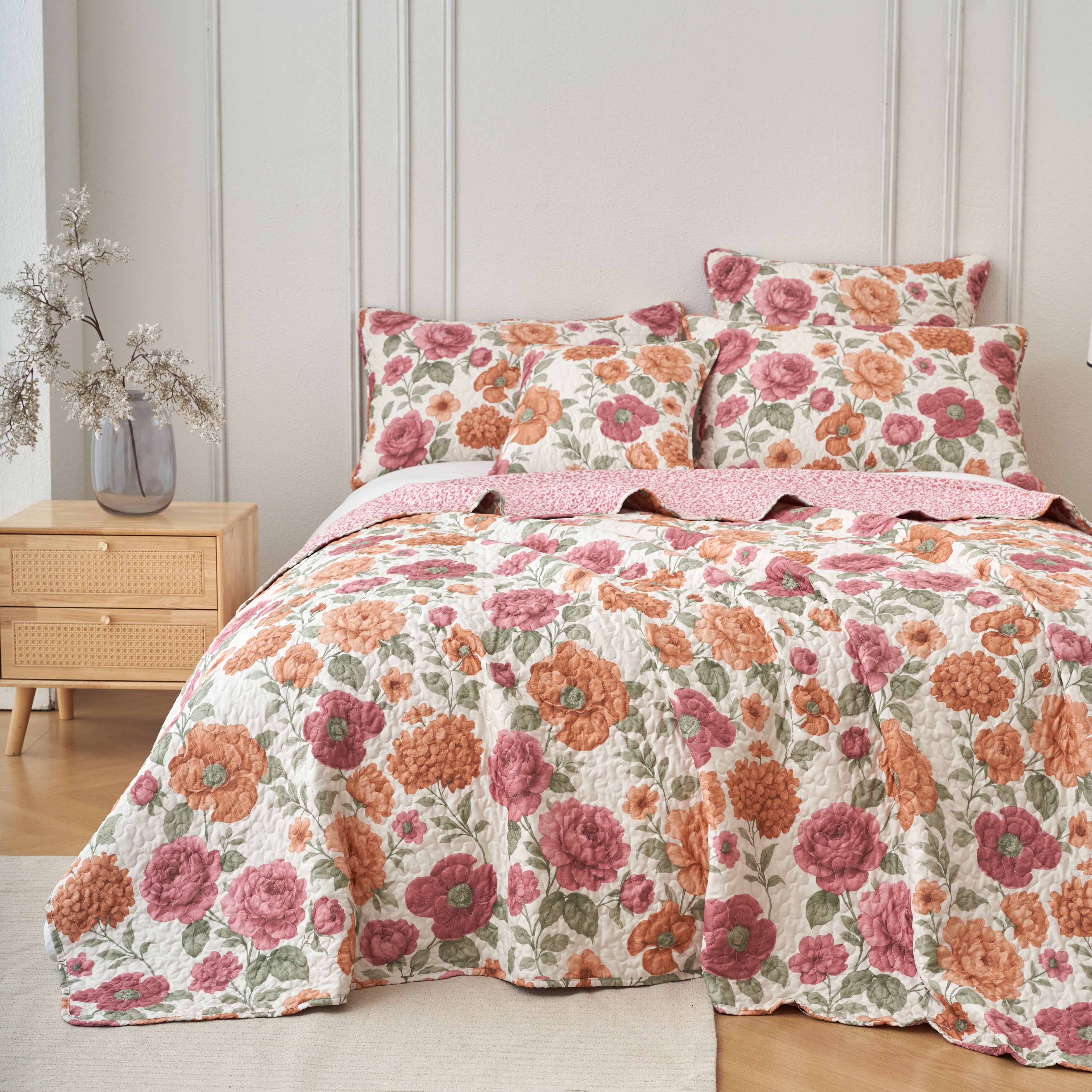 Terracotta rose floral microfiber quilt set with two pillow shams made up on a queen bed