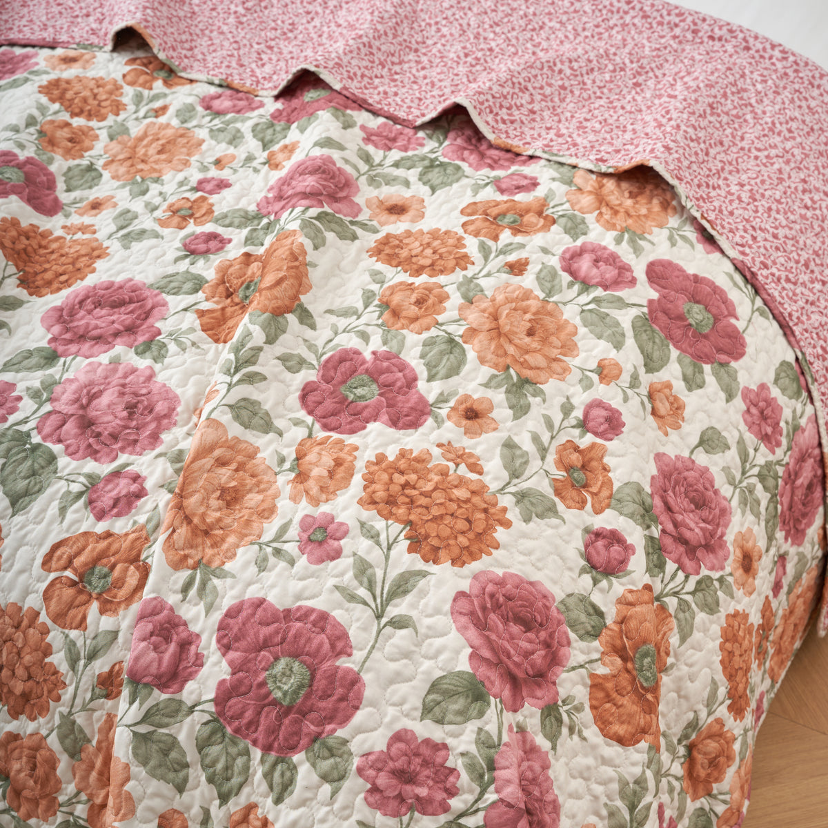 Detail of the terracotta floral print beside the reversible rose and ivory scroll pattern