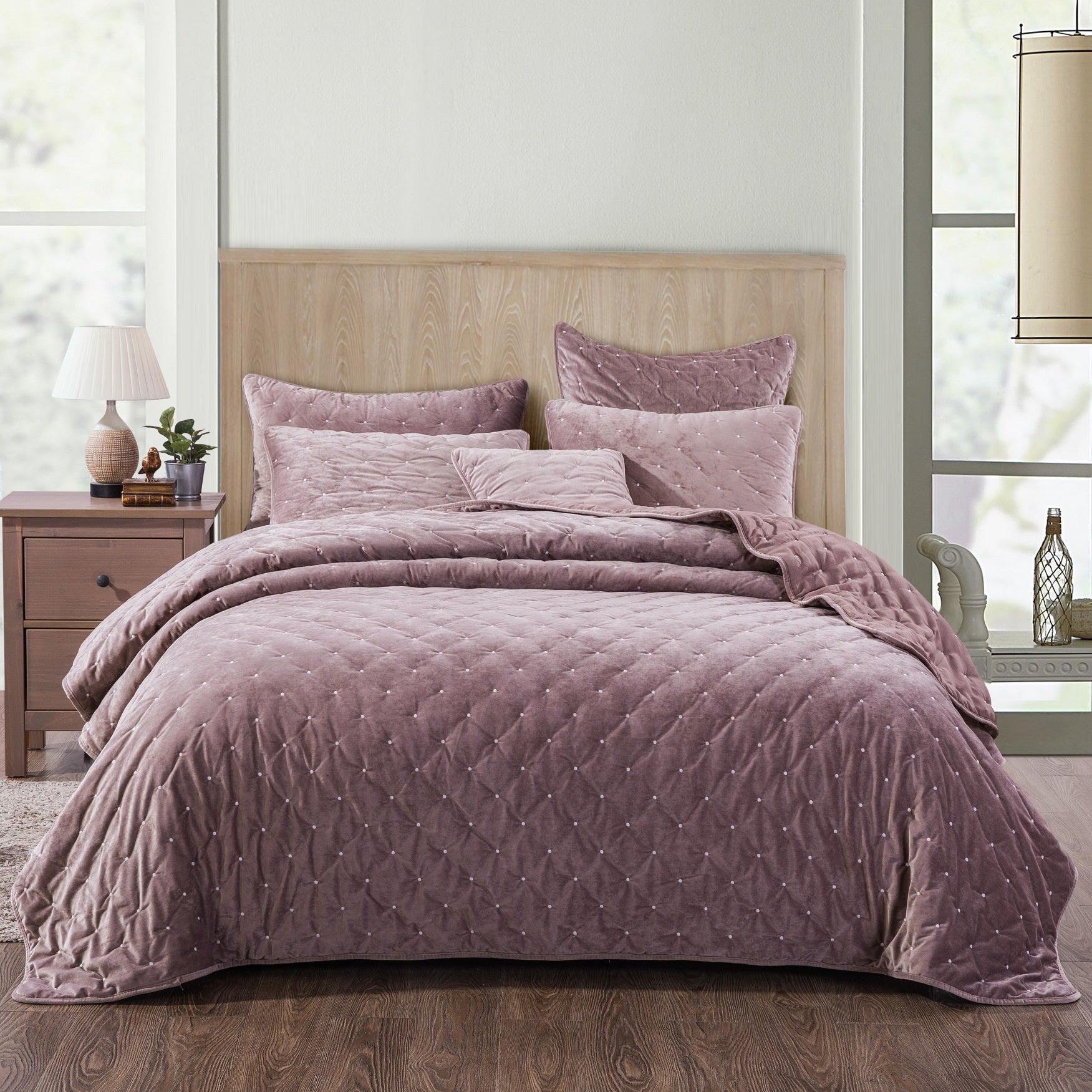 Tache Plush Dreams Purple Mauve Tufted Velvet Quilt Set Quilted purple bedding set on a bed in a bedroom with wooden headboard and nightstands.