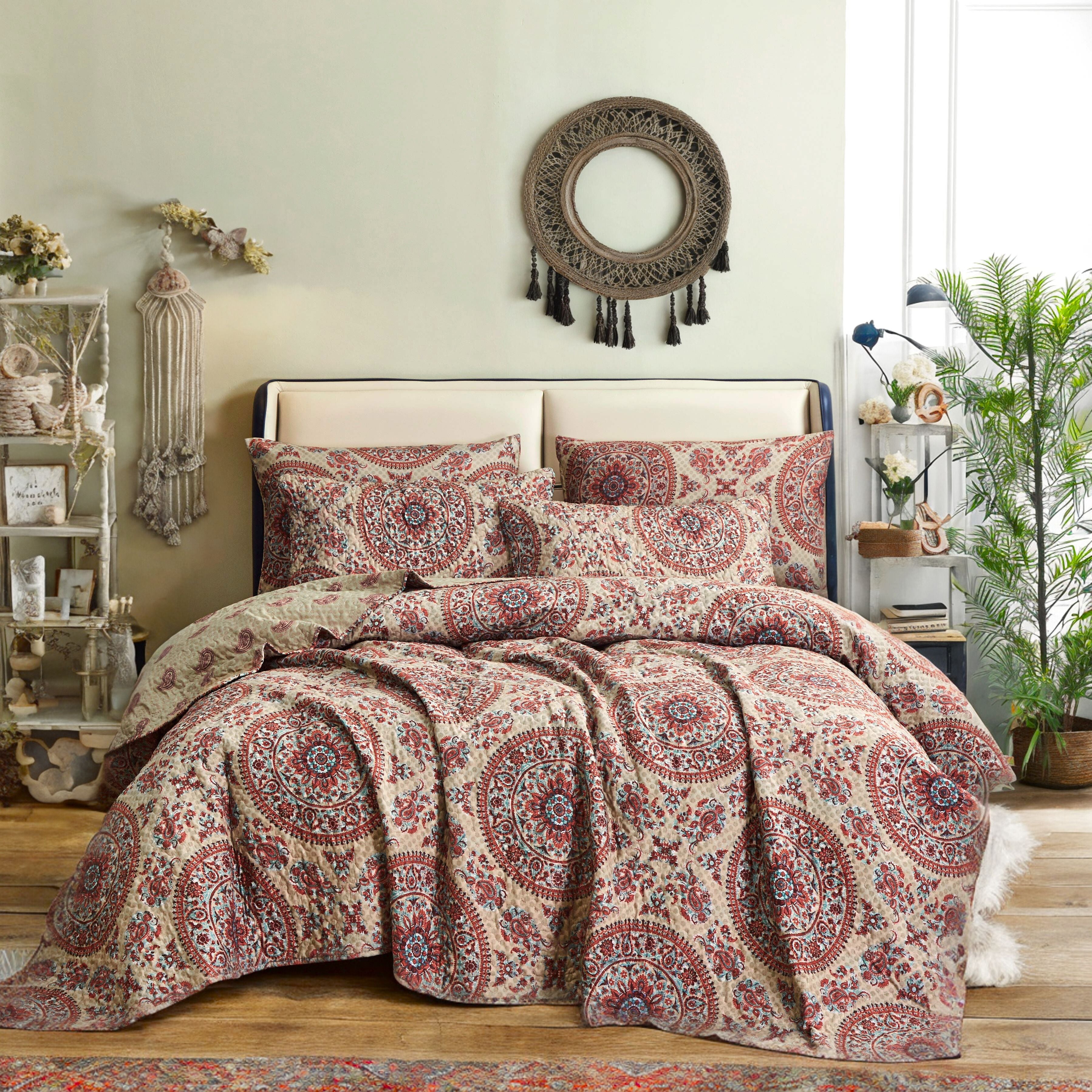 A Bohemian-style bedroom with a vibrant taupe beige and burgundy medallion print quilt and plush pillows