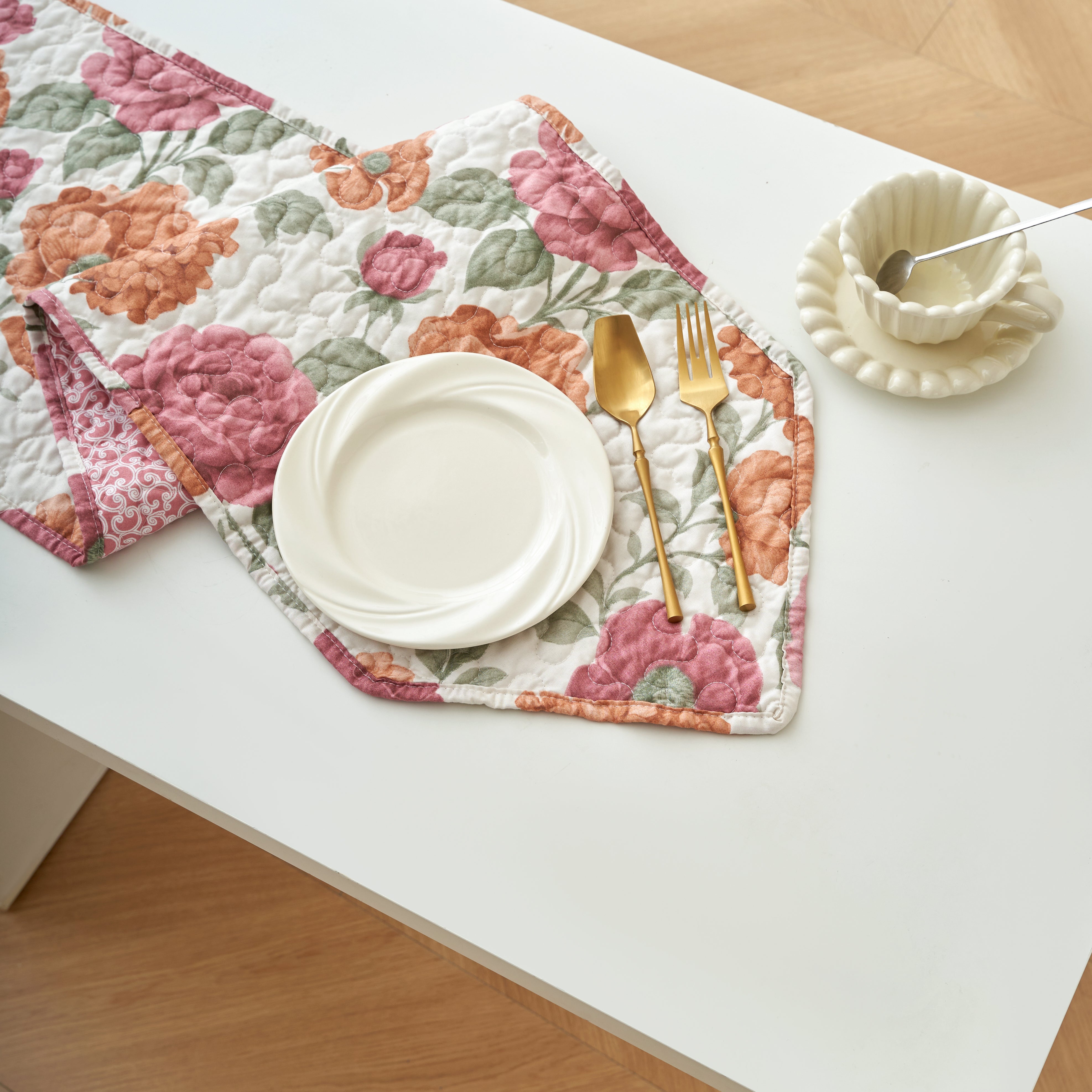 Rose scroll reversible quilted table runner folded to show both the floral and scroll sides
